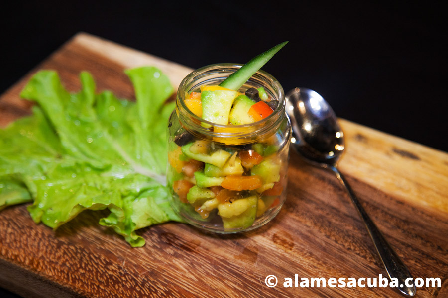 Ensalada de frutas y vegetales. Contiene mango, aguacate, aceitunas negras y pimientos, decorado con pepinos. Todo muy fresco, nutritivo y saludable.