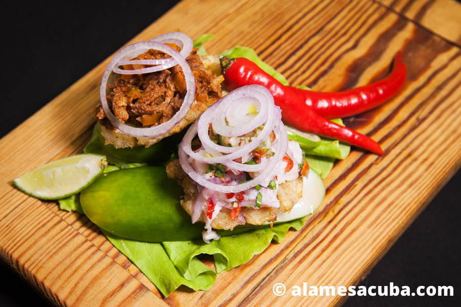 Dos tostones, uno con ceviche y pico de gallo y el otro con ropa vieja de res entomatada.